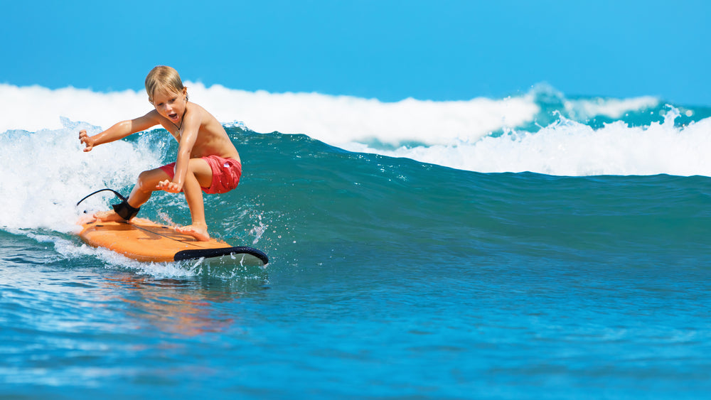 a boy surfing on a wave