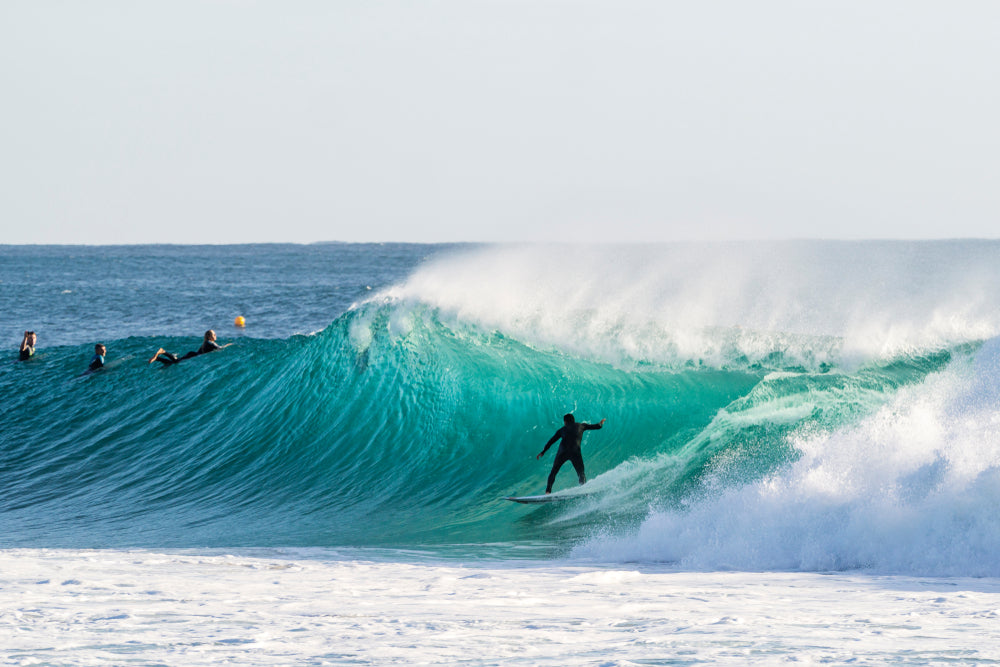 a surfer catching a big wave that is barelling