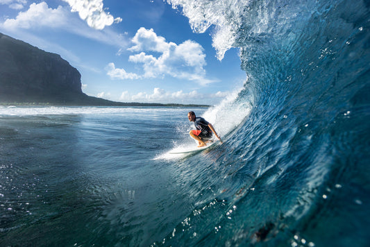 muscular surfer riding on big waves on the Indian Ocean island of Mauritius